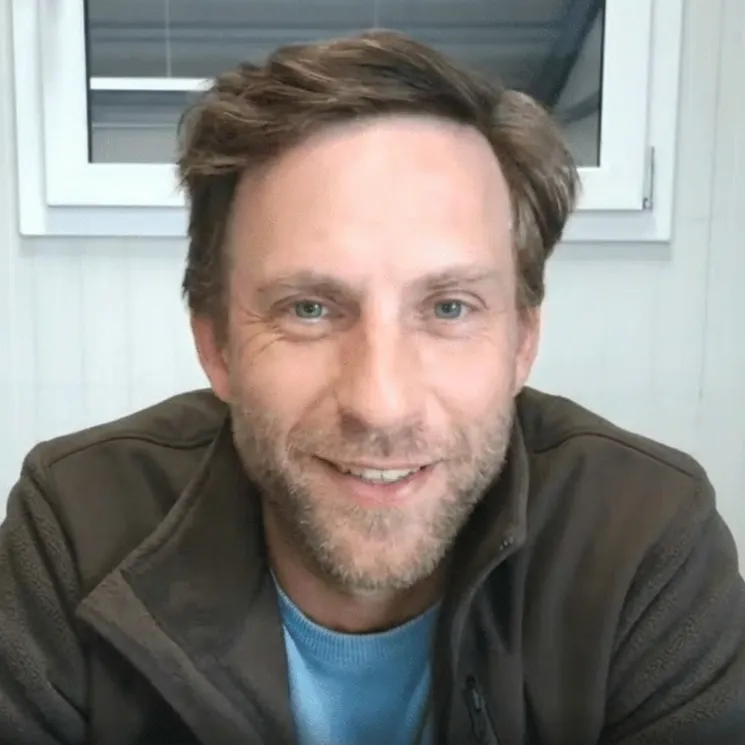 Porträt von Ramon Brinkhaus mit braunem Haar, Bart und dunklem Hoodie vor hellem Hintergrund – Ramon Brinkhaus von Barfhundgesund.