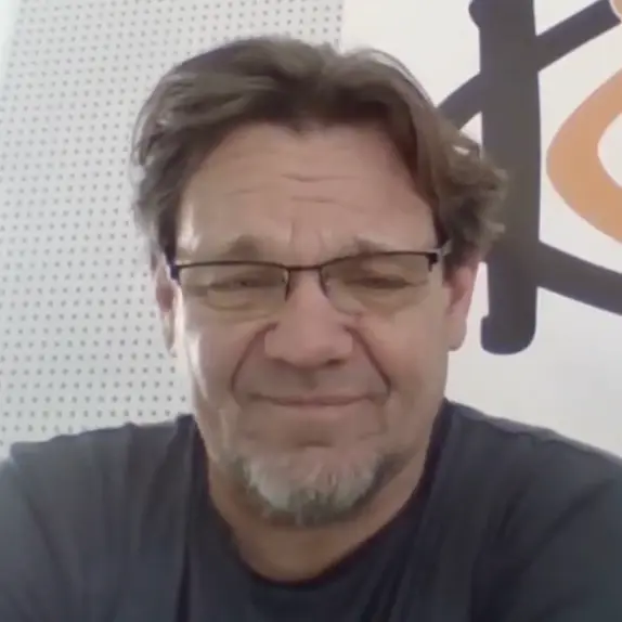 Michael Kähmann mit Brille, kurzem braunem Haar und Bart vor dunklem Hintergrund: Vertrauen und digitale Sichtbarkeit für Kähmann GmbH in Google und KI-Suchsystemen.