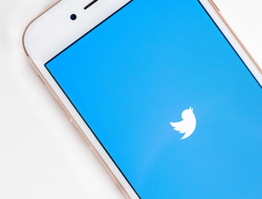 Smartphone mit blauem Twitter-Logo, hellen Rändern und klarer App-Ansicht. Thema: Mehr Follower auf Twitter generieren – aber wie?